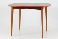 こちらはスウェーデンで買い付けたエクステンションダイニングテーブルです。天板は、珍しいラウンドスクエアの形状を採用しており、柔らかな印象と洗練されたデザインが魅力です。脚部は左右に開く構造で安定感があり、幕板は中央部分に向かってカットされているため、椅子の出し入れや座り心地にも配慮されています。また、来客時には付属の拡張板を使用することで、天板を簡単に広げられ、大人数での食事にも対応可能です。使い手の利便性を追求した設計が光る一品です。素材には、良質なチーク材とオーク材を使用しており、木目の美しさや温かみを感じられます。北欧家具ならではの高いデザイン性と実用性を兼ね備えたダイニングテーブルをぜひお楽しみください。