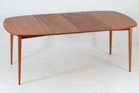 こちらはスウェーデンで買い付けたエクステンションダイニングテーブルです。天板は、珍しいラウンドスクエアの形状を採用しており、柔らかな印象と洗練されたデザインが魅力です。脚部は左右に開く構造で安定感があり、幕板は中央部分に向かってカットされているため、椅子の出し入れや座り心地にも配慮されています。また、来客時には付属の拡張板を使用することで、天板を簡単に広げられ、大人数での食事にも対応可能です。使い手の利便性を追求した設計が光る一品です。素材には、良質なチーク材とオーク材を使用しており、木目の美しさや温かみを感じられます。北欧家具ならではの高いデザイン性と実用性を兼ね備えたダイニングテーブルをぜひお楽しみください。