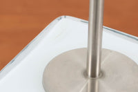 Per Lütken(ペル・ルッケン)が1980年代にデザインした「Kubus(キューブス)」シリーズのテーブルランプです。名前の通り、立方体(キューブ)をモチーフにしたホルムガードならではの厚みのある高品質なガラスが使用されており、点灯すると柔らかな光が広がり、空間に温かみと落ち着きを与えます。細いメタルの支柱が全体を引き締め、ミニマルで洗練されたデザインを際立たせています。大中小のサイズ展開がある中で、こちらは中サイズのモデルです。