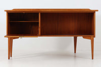 こちらはGoran Strandデザインのスウェーデン製ブーメラン型デスクで、Lelangs mobelfabrik社が製造したヴィンテージ家具です。チーク材とオーク材が使用されており、オーク材は脚や縁部分に施されており、スウェーデン家具らしい造りが特徴です。天板の奥側には返しがあり、実用性と美しさを兼ね備えています。デスクの後ろにはバックシェルフが設けられており、収納力も充実しています。温かみのある木材の組み合わせが、どんな空間にも調和し、優れた機能性とともに、ヴィンテージならではの魅力を感じさせてくれます。