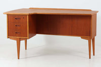 こちらはGoran Strandデザインのスウェーデン製ブーメラン型デスクで、Lelangs mobelfabrik社が製造したヴィンテージ家具です。チーク材とオーク材が使用されており、オーク材は脚や縁部分に施されており、スウェーデン家具らしい造りが特徴です。天板の奥側には返しがあり、実用性と美しさを兼ね備えています。デスクの後ろにはバックシェルフが設けられており、収納力も充実しています。温かみのある木材の組み合わせが、どんな空間にも調和し、優れた機能性とともに、ヴィンテージならではの魅力を感じさせてくれます。