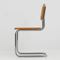 Marcel Breuerによる名作「Cesca Chair」です。ビーチ材のフレームにラタン張りの背もたれと座面を組み合わせ、軽やかな印象と快適な座り心地を実現しています。スチールパイプによるキャンティレバー構造が特徴で、浮遊感のある美しいフォルムはモダンデザインの象徴として高く評価されています。異素材が調和した洗練された佇まいはダイニングや書斎、店舗空間にもおすすめです。長年愛され続けるデザインとビンテージならではの風合いをお楽しみいただける一脚です。こちらのCesca Chairは、リプロダクト(復刻版)品となります。多くのリプロダクトが市場に出回っており、北欧地域でも使用されていることが確認されています。また、本チェアはデンマークディーラーより買い付けた品物になりますが、生産国、製造メーカーについては不明です。