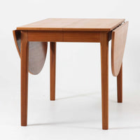 CJ Rosengaarden社によるエクステンションダイニングテーブルは、長方形の本体に両側バタフライ式の半円天板と中央拡張板2枚を備え、最大で8人がゆったりと囲める広さに対応します。温かみのあるチーク材と美しい木目、滑らかな金属レールによる開閉構造が魅力で、シーンに応じて柔軟に使える北欧ビンテージ家具の実用的な一台です。