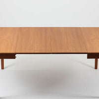 CJ Rosengaarden社によるエクステンションダイニングテーブルは、長方形の本体に両側バタフライ式の半円天板と中央拡張板2枚を備え、最大で8人がゆったりと囲める広さに対応します。温かみのあるチーク材と美しい木目、滑らかな金属レールによる開閉構造が魅力で、シーンに応じて柔軟に使える北欧ビンテージ家具の実用的な一台です。