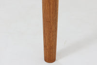 デンマークの名工Slagelse mobelvaerk社が手掛けたこちらのダイニングテーブルは、アーチ状の幕板が特徴であり、異なる素材の組み合わせが美しさを際立たせます。天板には上質なチーク材が用いられ、脚部にはナチュラルなオーク材が採用されています。また、幕板は強度と使い勝手が考慮され、通常時には4人、拡張時には6~8人が快適に使用できる設計となっています。