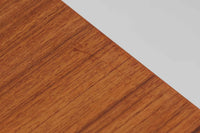 デンマークの名工Slagelse mobelvaerk社が手掛けたこちらのダイニングテーブルは、アーチ状の幕板が特徴であり、異なる素材の組み合わせが美しさを際立たせます。天板には上質なチーク材が用いられ、脚部にはナチュラルなオーク材が採用されています。また、幕板は強度と使い勝手が考慮され、通常時には4人、拡張時には6~8人が快適に使用できる設計となっています。