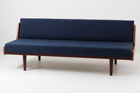 デンマークの名門家具メーカーGetama(ゲタマ)より、Hans J. Wegner(ハンス・J・ウェグナー)によってデザインされたビンテージのデイベッド「GE258」のご紹介です。チーク材のフレームに、希少な丸脚仕様が特徴的なモデルで、無駄のない美しい直線と有機的なフォルムが融合した北欧モダンデザインの代表作です。背もたれを後方に倒すことでベッドとしてもご使用いただける実用性の高い構造で、張地は落ち着いたネイビー系のファブリックで張り替え済みです。チーク材の木目が美しく、経年による味わいも感じられる逸品です。