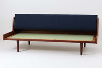 デンマークの名門家具メーカーGetama(ゲタマ)より、Hans J. Wegner(ハンス・J・ウェグナー)によってデザインされたビンテージのデイベッド「GE258」のご紹介です。チーク材のフレームに、希少な丸脚仕様が特徴的なモデルで、無駄のない美しい直線と有機的なフォルムが融合した北欧モダンデザインの代表作です。背もたれを後方に倒すことでベッドとしてもご使用いただける実用性の高い構造で、張地は落ち着いたネイビー系のファブリックで張り替え済みです。チーク材の木目が美しく、経年による味わいも感じられる逸品です。