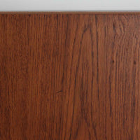 Borge Mogensen(ボーエ・モーエンセン)がFDB Moblerのために手掛けたC18ダイニングテーブルは、チーク材天板とオーク材脚部を組み合わせた北欧モダンを象徴するビンテージ家具で、直線的で端正なプロポーションと安定感のあるT字脚構造が特徴です。拡張板を備え、来客時や家族構成の変化にも柔軟に対応でき、日常使いから特別な食卓まで幅広く活躍します。現在はCarl Hansen & Son社より復刻生産されていますが、チーク材天板とオーク材脚部という素材の組み合わせは当時のビンテージ品ならではの仕様で、脚部に用いられた真鍮製の留め具も現行品とは異なる形状となっています。経年により深みを増した木肌と、実用性を重視したモーエンセンらしい設計思想、そしてビンテージならではのディテールを味わえる一台です。