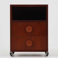 特徴的な丸型取手が目を引くこちらのサイドテーブルは、温かみのあるチーク材とシンプルな構造美が調和した北欧ビンテージ家具です。オープンスペースと2杯の引き出しに加え、英国製「ORBIT」キャスターを備え、滑らかな移動が可能です。幅40cmとコンパクトながらも機能性に優れており、ベッドサイドやソファ横の収納兼テーブルとして幅広く活躍します。実用性と遊び心を兼ね備えた一点物として、空間に心地よいアクセントを加えてくれます。