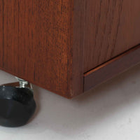 特徴的な丸型取手が目を引くこちらのサイドテーブルは、温かみのあるチーク材とシンプルな構造美が調和した北欧ビンテージ家具です。オープンスペースと2杯の引き出しに加え、英国製「ORBIT」キャスターを備え、滑らかな移動が可能です。幅40cmとコンパクトながらも機能性に優れており、ベッドサイドやソファ横の収納兼テーブルとして幅広く活躍します。実用性と遊び心を兼ね備えた一点物として、空間に心地よいアクセントを加えてくれます。