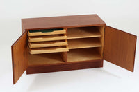 Poul Hundevadデザインのキャビネットです。扉の取手に鍵を使用したデンマークならではのデザインで、シンプルな本体には扉のみが設置されています。北欧から買い付けたもので、良質なチーク材が使用され、温かみのある雰囲気を醸し出します。製造はHundevad自身の家具工房、Hundevad&Co.によるもので、デンマークの厳しい品質基準を満たした「DANISH FURNITUREmAKE'S CONTROL」の刻印が施されています。さらに、小引き出しや高さ調整可能な棚板が備わっており、機能性も兼ね備えた優れたアイテムです。