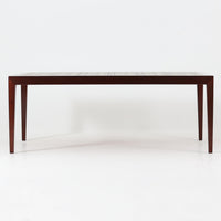 Severin Hansen Jr.によってデザインされ、Haslev社から製造されたセンターテーブルは、マホガニー材のフレームにロイヤルコペンハーゲン製Bacaシリーズのタイルをあしらった上質な一台です。精緻なカットが施された脚部と幾何学的なタイル装飾が調和し、クラフトマンシップと芸術性を兼ね備えた北欧ビンテージらしい佇まいを見せています。幅133cmのサイズ感はリビングの主役として十分な存在感を放ち、コーヒーテーブルとしてはもちろん、装飾台としてもおすすめです。