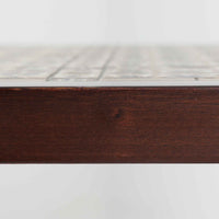 Severin Hansen Jr.によってデザインされ、Haslev社から製造されたセンターテーブルは、マホガニー材のフレームにロイヤルコペンハーゲン製Bacaシリーズのタイルをあしらった上質な一台です。精緻なカットが施された脚部と幾何学的なタイル装飾が調和し、クラフトマンシップと芸術性を兼ね備えた北欧ビンテージらしい佇まいを見せています。幅133cmのサイズ感はリビングの主役として十分な存在感を放ち、コーヒーテーブルとしてはもちろん、装飾台としてもおすすめです。