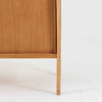B. Fridhagenがデザインし、スウェーデンのBodafors社によって製造されたこちらのボードは、上質なオーク材を用いた小ぶりなサイズ感と、無駄を省いた洗練された意匠が魅力の一台です。スライド扉を開けると左右に仕切られた収納部が現れ、日用品や書籍の整理に最適です。細身の脚と角の立ったフレームが全体に軽やかな印象を与え、空間を圧迫せず設置できます。シンプルながらも素材の美しさと北欧らしい実用性が際立つ、希少なビンテージ家具です。