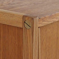 B. Fridhagenがデザインし、スウェーデンのBodafors社によって製造されたこちらのボードは、上質なオーク材を用いた小ぶりなサイズ感と、無駄を省いた洗練された意匠が魅力の一台です。スライド扉を開けると左右に仕切られた収納部が現れ、日用品や書籍の整理に最適です。細身の脚と角の立ったフレームが全体に軽やかな印象を与え、空間を圧迫せず設置できます。シンプルながらも素材の美しさと北欧らしい実用性が際立つ、希少なビンテージ家具です。