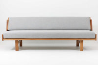 デンマークを代表する家具デザイナー、ハンス・J・ウェグナーによるデザインのデイベッド。シンプルで洗練されたフォルムと機能美が融合した、GATAmA社製の北欧ビンテージ家具です。フレームには経年により色味が濃くなったオーク材が使用され、優しい木の風合いが感じられる仕上がり。クッションは新しく張り替えており、快適な座り心地を提供します。背もたれ部分はスムーズに動かせる仕様で、簡単にデイベッドとして使用可能。リビングのソファとしてはもちろん、ゲスト用のベッドとしても活躍します。北欧デザインらしいミニマルで実用的な構造が特徴で、どんな空間にも馴染みやすい一台です。