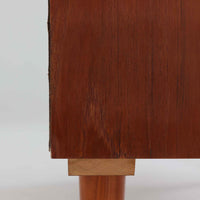 Domino Mobler社製のサイドボードは、北欧デンマークのビンテージ家具らしいシンプルかつ機能的なデザインが魅力です。チーク材を用いた温かみのある木目と深みのある色調が空間に落ち着きを与えます。左側には4杯の引き出し、右側にはスライド扉付きの収納棚を備え、食器や日用品をすっきり収めることが可能です。特徴的なスクエア型の木製ハンドルや細身の脚部が洗練された印象を与え、ダイニングやリビングでの収納家具としてだけでなく、テレビボードや飾り棚としても活躍する実用性と存在感を兼ね備えています。年月を経た風合いがより一層の魅力を引き立てる逸品です。