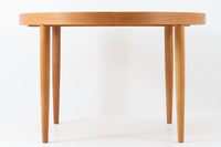 美しい木目のオーク材で作られたデンマーク製のビンテージダイニングテーブルです。シンプルでありながら北欧らしい洗練されたデザインが魅力で、エクステンション機能により天板を伸長して大人数にも対応可能です。天板を閉じた状態では直径のある円形テーブルとして、拡張時には楕円形になり広々とご使用いただけます。丸みを帯びた天板のエッジと先細りの脚が軽やかで、どんな空間にも調和します。Danish Controlの刻印も確認でき、品質の高さが伺える逸品です。北欧モダンな空間演出におすすめの一台です。