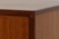 FDBモブラーでBorge mogensenの後任としてアートディレクターを務めたPoul m. Voltherによる、美しく洗練されたキャビネット。良質なマホガニー材の本体に、ビーチ材の脚部を組み合わせたコントラストが魅力です。真鍮の丸い鍵穴が特徴的な3枚の扉を備え、中央には調節可能な棚、両側には精巧な蟻継ぎが施された移動式の引き出しを配しています。下部には真鍮の俵型ハンドル付きの引き出しが3杯並び、細部へのこだわりが際立ちます。また、室内で靴を履く文化に配慮し、脚先には汚れ防止のための濃い塗装が施されています。1950年代にデザインされた本作は、先細りの脚やストレッチャーがミニマルな美しさを際立たせる一方、シンメトリーなフォルムや真鍮の装飾が伝統的なエレガンスを醸し出し、モダンとクラシックが調和した逸品です。