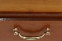 FDBモブラーでBorge mogensenの後任としてアートディレクターを務めたPoul m. Voltherによる、美しく洗練されたキャビネット。良質なマホガニー材の本体に、ビーチ材の脚部を組み合わせたコントラストが魅力です。真鍮の丸い鍵穴が特徴的な3枚の扉を備え、中央には調節可能な棚、両側には精巧な蟻継ぎが施された移動式の引き出しを配しています。下部には真鍮の俵型ハンドル付きの引き出しが3杯並び、細部へのこだわりが際立ちます。また、室内で靴を履く文化に配慮し、脚先には汚れ防止のための濃い塗装が施されています。1950年代にデザインされた本作は、先細りの脚やストレッチャーがミニマルな美しさを際立たせる一方、シンメトリーなフォルムや真鍮の装飾が伝統的なエレガンスを醸し出し、モダンとクラシックが調和した逸品です。