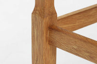 デンマークの建築家Henning Kjaernulf(ヘニング・ケアヌルフ)によってデザインされた、オーク無垢材のドロップリーフ式センターテーブルです。製造は高品質な家具で知られるEGモブラー社。無垢材ならではの美しい木目と、クラシカルで彫刻的な脚部のラインが印象的です。天板は両側に開閉式のリーフが備わっており、来客時や作業時には広げてスペースを拡張できるなど、実用性も兼ね備えています。テーブルの高さはやや高めの設計で、ソファ前に置いても手元が使いやすく、センターテーブルとして快適にお使いいただけます。必要に応じてサイドテーブルやティーテーブルとしても活躍する、用途の広い一台です。