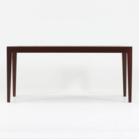 Nils Thorssonがデザインを手掛け、Royal CopenhagenのBACAシリーズのタイルを天板に配したセンターテーブルです。家具メーカーHaslev社により製作され、マホガニー材の落ち着いた木目と、幾何学的で温かみのあるタイル意匠が美しく調和しています。直線的で端正なフォルムは空間をすっきりと見せ、リビングの主役としてはもちろん、ソファ前のローテーブルとしても活躍。経年により深みを増した木部と味わい豊かな陶板が、北欧ビンテージならではの存在感を放つ一品です。