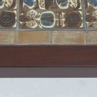 Nils Thorssonがデザインを手掛け、Royal CopenhagenのBACAシリーズのタイルを天板に配したセンターテーブルです。家具メーカーHaslev社により製作され、マホガニー材の落ち着いた木目と、幾何学的で温かみのあるタイル意匠が美しく調和しています。直線的で端正なフォルムは空間をすっきりと見せ、リビングの主役としてはもちろん、ソファ前のローテーブルとしても活躍。経年により深みを増した木部と味わい豊かな陶板が、北欧ビンテージならではの存在感を放つ一品です。