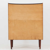 デンマーク製のチーク材によるライティングビューロです。幅85cmと程よいサイズ感で、上段には小引き出しを備え、小物や文具を整理しやすい構造になっています。中央のライティング天板は手前にスライドさせることで作業スペースが確保でき、書き物やノートPCの使用に最適です。さらに、内部には鏡が備わっており、ドレッサーとしても活用できる実用的なデザインです。下段には容量の大きな引き出しが3杯あり、衣類や書類の収納にも対応します。チーク材特有の温かみのある木目と経年による艶が味わい深く、実用性と美観を兼ね備えたビンテージ家具です。