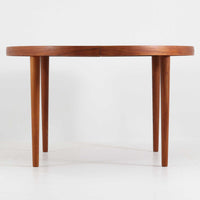 デンマーク製円形エクステンションダイニングテーブルです。チーク材特有の温かみある木目が美しく、滑らかな質感が空間に上質な印象を与えます。幕板と天板が一体化した構造により、すっきりとした見た目と安定感のある構造を両立。天板中央の拡張板を取り付けることで人数や用途に合わせてサイズを調整でき、普段使いから来客時まで幅広く対応します。テーパー脚が軽やかな印象を添え、経年で深みを増したチークの色合いが北欧ビンテージならではの魅力を引き立てます。