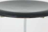 1954年、デンマークのデザイナー、Arne Jacobsen(アルネ・ヤコブセン)によって発表された3本脚のスツール、「DOT(ドット)」。このスツールは、ヤコブセンが手がけた「ルードブレ市庁舎」のロビーで待合席として使用されていました。3本脚のモデルはビンテージ品のみで入手可能です。オフィスや自宅での日常的な使用はもちろん、予備の椅子としても便利なこのスツールは、シンプルなデザインが魅力です。座面の中央がわずかにくぼんでおり、座った際にフィット感を生み出します。シンプルながらもヤコブセンのこだわりが感じられ、また、単なるスツールとしてだけでなく、ソファの横に置いて本や小物を置くサイドテーブルとしても活用できます。