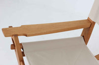 Hans J. Wegnerが1967年にデザインしたロッキングチェア「キーホールチェア(GE673)」は、GETAmA社製の一脚です。特徴的な「鍵穴」のような形状の座面固定方法が名前の由来で、左右のアーム下に引っ掛けた2本の棒が座面を支える構造です。帆布製の背もたれと座面は、ハンモックのような座り心地を提供し、まるで包み込まれるような安心感を感じさせます。ロッキングチェアならではの揺れと、程よい可動領域が特徴で、家の中でゆったりとくつろぐのに最適です。座面は簡単に取り外せ、クリーニングにも配慮されています。軽量で機能性とデザインが見事に調和した、ウェグナーならではの作品です。