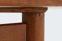 台形を基にした多角形の天板が特徴的な、美しいビンテージのセンターテーブル。心地よい木目が際立つウォールナット材の天板と、ナチュラルな風合いのビーチ材の組み合わせが、温かみのある佇まいを演出しています。天板と脚部、棚板の接続部には丸い真鍮があしらわれ、シンプルなフォルムの中に洗練されたアクセントを加えています。また、脚部をつなぐ幕板の形状も独特で、細部にまでこだわりが感じられるデザインです。デザイナーは不明ですが、細部の仕上げや素材選びから高いクオリティがうかがえる一品。モダンとクラシックが絶妙に調和した、上質なビンテージテーブルです。