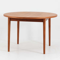 Nils Jonssonがデザインし、Troeds社より発表された円形エクステンションダイニングテーブル「Malta」です。チーク材の温かみある木目が美しく、直径110cmの天板は来客時には拡張板を追加することで大きな楕円形へと広がり、シーンに応じた柔軟な使い方が可能です。拡張板は円形では珍しく折り畳んで本体に収納することができ、機能性と利便性を兼ね備えています。脚部は細身で軽快ながら安定感があり、北欧家具らしいシンプルで機能的な構造が魅力です。日常使いはもちろん、来客時や家族の集まりにも最適で、経年による素材の風合いがビンテージならではの味わいを深めています。
