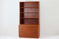 デンマークを代表する家具デザイナー、Borge mogensen(ボーエ・モーエンセン)によってデザインされた、Soborg mobler社製のディスプレイシェルフです。上部には本や雑貨を美しく並べられるオープンシェルフ、下部には4杯の引き出しが備わっており、収納力と見せる楽しさを兼ね備えた実用的な構成となっています。素材にはチーク材が使用されており、温かみのある木目と落ち着いた色味が空間に上質な印象を与えます。背面にはメーカーラベルが残っており、モーエンセン作品としての価値を感じさせる一品です。幅100cmと程よいサイズ感で、リビングや書斎など幅広いシーンにおすすめです。