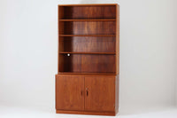 デンマークの巨匠ボーエ・モーエンセンがデザインした、Soborg mobler社製のビンテージディスプレイシェルフ。1950~70年代に製造された北欧家具の名作です。チーク材の美しい木目が際立ち、温かみのある風合いが魅力。上部はオープンシェルフ、下部には収納キャビネットを備え、実用性にも優れています。可動棚により、収納スペースを自由に調整可能。モーエンセンらしいシンプルな掘り込み取っ手が施された洗練されたデザイン。ビンテージならではの風合いを楽しめる、北欧家具の逸品です。