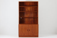 デンマークの巨匠ボーエ・モーエンセンがデザインした、Soborg mobler社製のビンテージディスプレイシェルフ。1950~70年代に製造された北欧家具の名作です。チーク材の美しい木目が際立ち、温かみのある風合いが魅力。上部はオープンシェルフ、下部には収納キャビネットを備え、実用性にも優れています。可動棚により、収納スペースを自由に調整可能。モーエンセンらしいシンプルな掘り込み取っ手が施された洗練されたデザイン。ビンテージならではの風合いを楽しめる、北欧家具の逸品です。