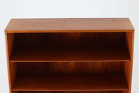 デンマークの巨匠ボーエ・モーエンセンがデザインした、Soborg mobler社製のビンテージディスプレイシェルフ。1950~70年代に製造された北欧家具の名作です。チーク材の美しい木目が際立ち、温かみのある風合いが魅力。上部はオープンシェルフ、下部には収納キャビネットを備え、実用性にも優れています。可動棚により、収納スペースを自由に調整可能。モーエンセンらしいシンプルな掘り込み取っ手が施された洗練されたデザイン。ビンテージならではの風合いを楽しめる、北欧家具の逸品です。