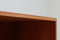 デンマークの巨匠ボーエ・モーエンセンがデザインした、Soborg mobler社製のビンテージディスプレイシェルフ。1950~70年代に製造された北欧家具の名作です。チーク材の美しい木目が際立ち、温かみのある風合いが魅力。上部はオープンシェルフ、下部には収納キャビネットを備え、実用性にも優れています。可動棚により、収納スペースを自由に調整可能。モーエンセンらしいシンプルな掘り込み取っ手が施された洗練されたデザイン。ビンテージならではの風合いを楽しめる、北欧家具の逸品です。