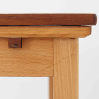 チーク材とビーチ材を組み合わせたデンマーク製のエクステンションダイニングテーブル。天板には深みのあるチーク材、脚部、幕板、拡張板には明るいビーチ材を使用し、異素材のコントラストが洗練された印象を与えます。幅100cmとコンパクトながら、両側に伸長式リーフを備え、用途に応じて天板の拡張が可能。シンプルで堅牢なつくりは、限られた空間にもフィットし、経年変化による木材の味わいとともに、長く愛用できる北欧ビンテージ家具の魅力が詰まった一台です。