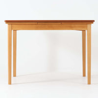 チーク材とビーチ材を組み合わせたデンマーク製のエクステンションダイニングテーブル。天板には深みのあるチーク材、脚部、幕板、拡張板には明るいビーチ材を使用し、異素材のコントラストが洗練された印象を与えます。幅100cmとコンパクトながら、両側に伸長式リーフを備え、用途に応じて天板の拡張が可能。シンプルで堅牢なつくりは、限られた空間にもフィットし、経年変化による木材の味わいとともに、長く愛用できる北欧ビンテージ家具の魅力が詰まった一台です。