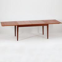 Vamo Mobelfabrikによって製造されたこちらのエクステンションダイニングテーブルは、チーク材の豊かな木目と重厚感のある質感が魅力の北欧ビンテージ家具で、幅150cmから最大270cmまで拡張可能な構造により、来客時や家族団らんの場にも柔軟に対応します。天板下に格納された2枚の中板を引き出して使用するシステムは実用性と美しさを兼ね備え、シャープなエッジと丸みを帯びた脚部が洗練された佇まいを演出します。デザイナー不明ながら、Vamo社ならではの確かな造りとDanish Controlラベルが品質の高さを物語る一台です。