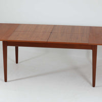 Vamo Mobelfabrikによって製造されたこちらのエクステンションダイニングテーブルは、チーク材の豊かな木目と重厚感のある質感が魅力の北欧ビンテージ家具で、幅150cmから最大270cmまで拡張可能な構造により、来客時や家族団らんの場にも柔軟に対応します。天板下に格納された2枚の中板を引き出して使用するシステムは実用性と美しさを兼ね備え、シャープなエッジと丸みを帯びた脚部が洗練された佇まいを演出します。デザイナー不明ながら、Vamo社ならではの確かな造りとDanish Controlラベルが品質の高さを物語る一台です。