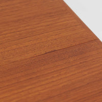 Vamo Mobelfabrikによって製造されたこちらのエクステンションダイニングテーブルは、チーク材の豊かな木目と重厚感のある質感が魅力の北欧ビンテージ家具で、幅150cmから最大270cmまで拡張可能な構造により、来客時や家族団らんの場にも柔軟に対応します。天板下に格納された2枚の中板を引き出して使用するシステムは実用性と美しさを兼ね備え、シャープなエッジと丸みを帯びた脚部が洗練された佇まいを演出します。デザイナー不明ながら、Vamo社ならではの確かな造りとDanish Controlラベルが品質の高さを物語る一台です。