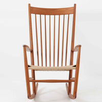 Hans J. Wegner(ハンス・J・ウェグナー)がデザインし、FDB Mobler社が製造したロッキングチェア「J16」。美しいチーク材のフレームとペーパーコードの座面が融合した、北欧ビンテージ家具を代表する一脚です。ハイバックと広めのアームが包み込むような座り心地を生み、ロッキングの揺れが心地よい安らぎをもたらします。経年により深みを増したチーク材の風合いが空間に静かな存在感を添え、読書やリラックスタイムに最適です。チーク材のモデルは希少で、現地デンマークのオークションで入手した確かな逸品です。