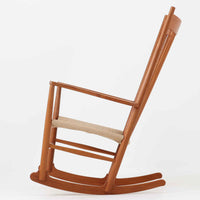 Hans J. Wegner(ハンス・J・ウェグナー)がデザインし、FDB Mobler社が製造したロッキングチェア「J16」。美しいチーク材のフレームとペーパーコードの座面が融合した、北欧ビンテージ家具を代表する一脚です。ハイバックと広めのアームが包み込むような座り心地を生み、ロッキングの揺れが心地よい安らぎをもたらします。経年により深みを増したチーク材の風合いが空間に静かな存在感を添え、読書やリラックスタイムに最適です。チーク材のモデルは希少で、現地デンマークのオークションで入手した確かな逸品です。