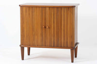 北欧デンマークで製造された、蛇腹扉が特徴的なビンテージキャビネットです。素材にはビーチ材と思われる無垢材や突板が使用されており、ステイン塗装により落ち着いたブラウンカラーに仕上げられています。前面には細かな縦ラインが連続する蛇腹扉が配され、開閉時に滑らかに動く美しい構造が魅力です。内部には棚板が一枚付属しており、収納としての機能性も十分です。丸脚や小さな丸い取っ手も北欧らしい柔らかなディテールで、リビングや玄関、寝室などさまざまな空間に自然に溶け込む一台です。