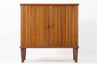 北欧デンマークで製造された、蛇腹扉が特徴的なビンテージキャビネットです。素材にはビーチ材と思われる無垢材や突板が使用されており、ステイン塗装により落ち着いたブラウンカラーに仕上げられています。前面には細かな縦ラインが連続する蛇腹扉が配され、開閉時に滑らかに動く美しい構造が魅力です。内部には棚板が一枚付属しており、収納としての機能性も十分です。丸脚や小さな丸い取っ手も北欧らしい柔らかなディテールで、リビングや玄関、寝室などさまざまな空間に自然に溶け込む一台です。