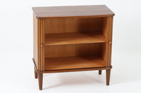 北欧デンマークで製造された、蛇腹扉が特徴的なビンテージキャビネットです。素材にはビーチ材と思われる無垢材や突板が使用されており、ステイン塗装により落ち着いたブラウンカラーに仕上げられています。前面には細かな縦ラインが連続する蛇腹扉が配され、開閉時に滑らかに動く美しい構造が魅力です。内部には棚板が一枚付属しており、収納としての機能性も十分です。丸脚や小さな丸い取っ手も北欧らしい柔らかなディテールで、リビングや玄関、寝室などさまざまな空間に自然に溶け込む一台です。