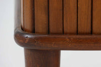 北欧デンマークで製造された、蛇腹扉が特徴的なビンテージキャビネットです。素材にはビーチ材と思われる無垢材や突板が使用されており、ステイン塗装により落ち着いたブラウンカラーに仕上げられています。前面には細かな縦ラインが連続する蛇腹扉が配され、開閉時に滑らかに動く美しい構造が魅力です。内部には棚板が一枚付属しており、収納としての機能性も十分です。丸脚や小さな丸い取っ手も北欧らしい柔らかなディテールで、リビングや玄関、寝室などさまざまな空間に自然に溶け込む一台です。